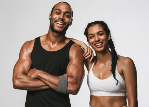 Photo of a happy man and woman in workout clothes covered in sweat