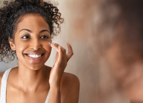 Photo of a woman applying skincare products to her face