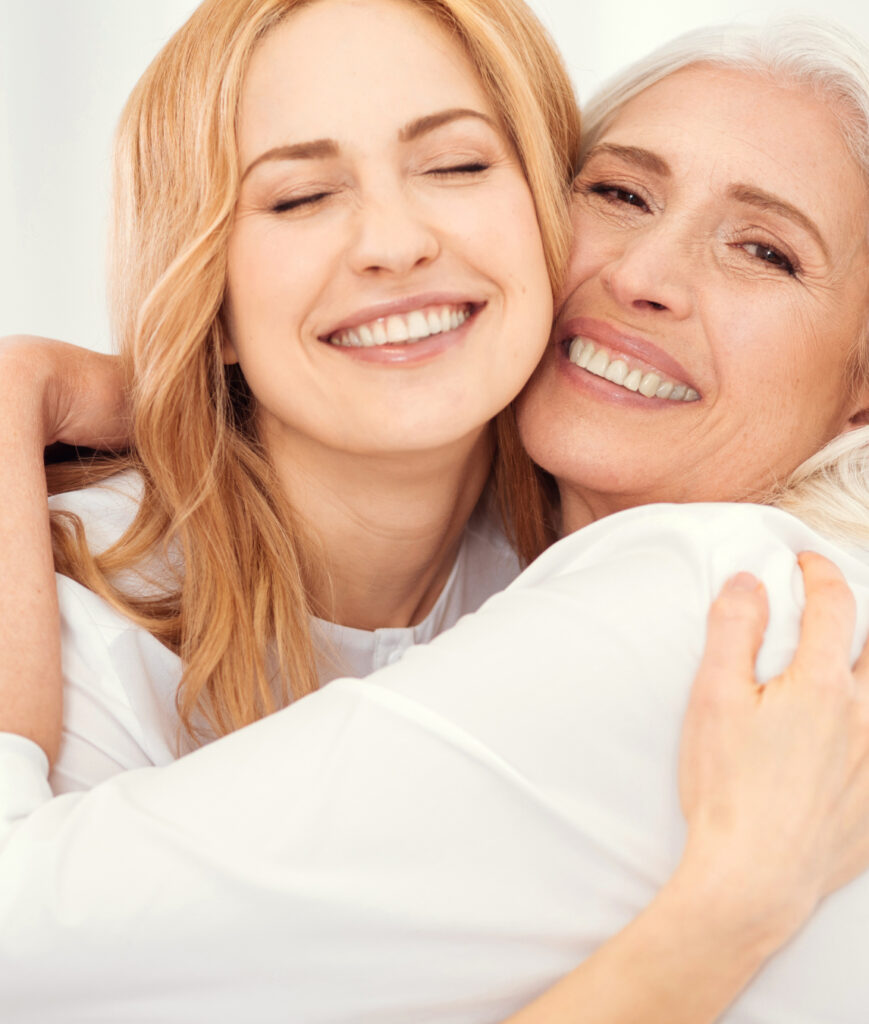 Photo of an older woman hugging her adult daughter