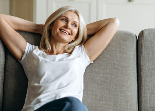 Photo of a happy older woman sitting on a couch