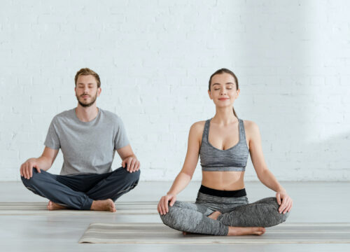 Photo of a woman and man doing yoga